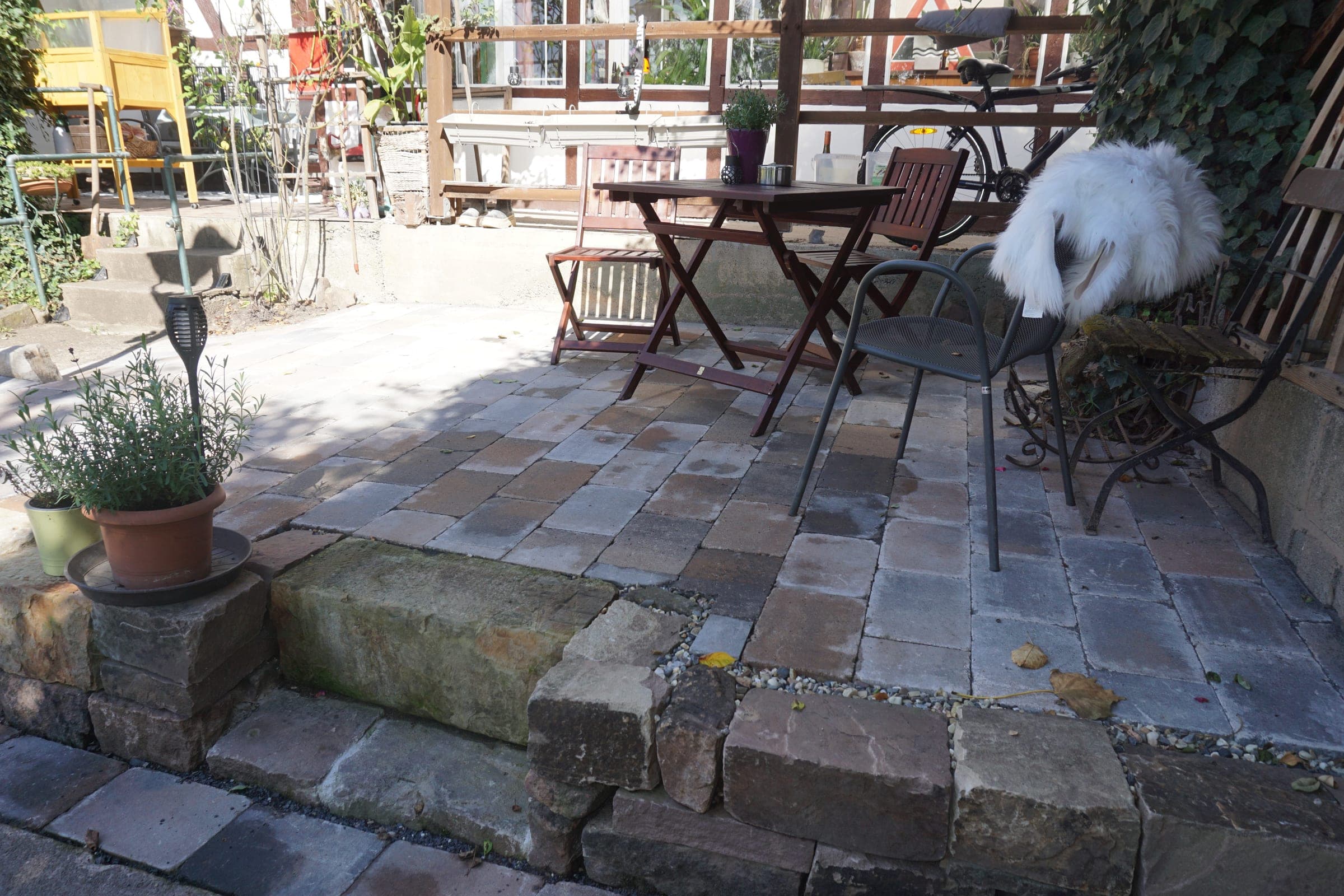 Pflasterterrasse aus Sandstein mit Sitzmöbeln