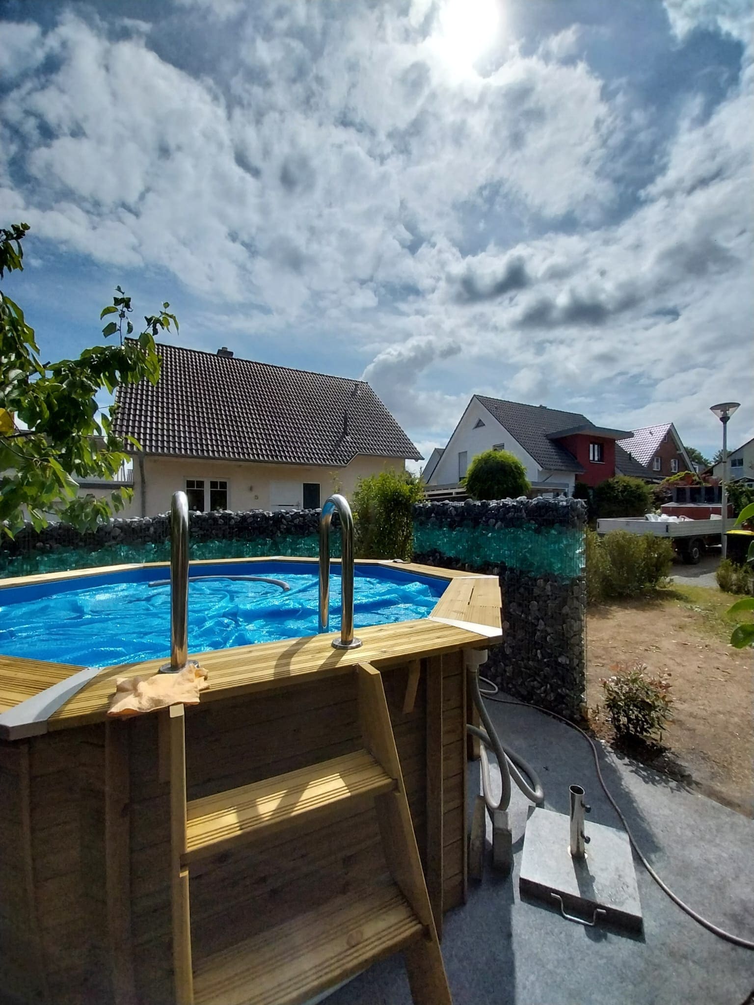 Poolbereich mit Gabionen-Sichtschutz und Heckenpflanzung